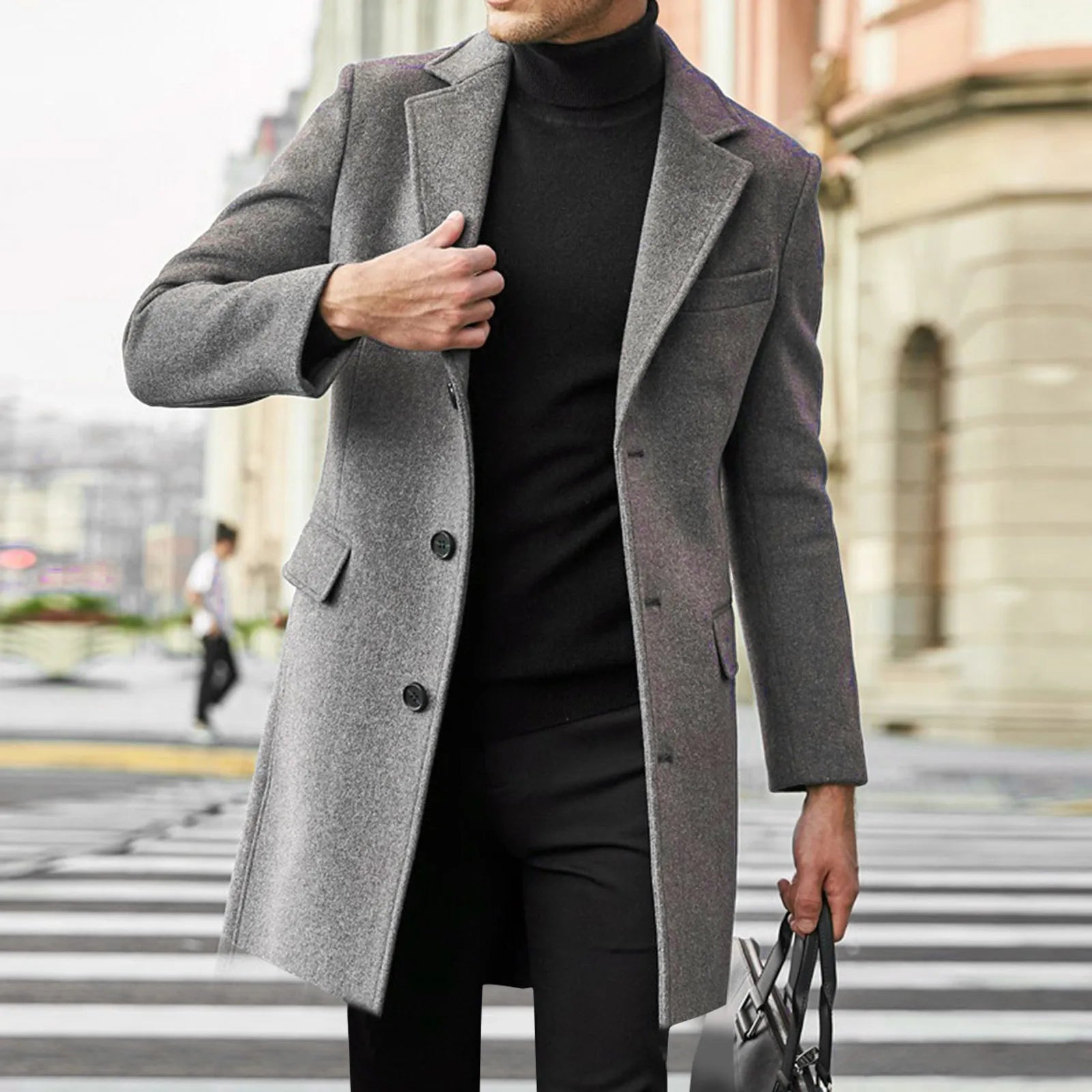 Man wearing grey men's tailored overcoat with notched lapel and button closure on city street