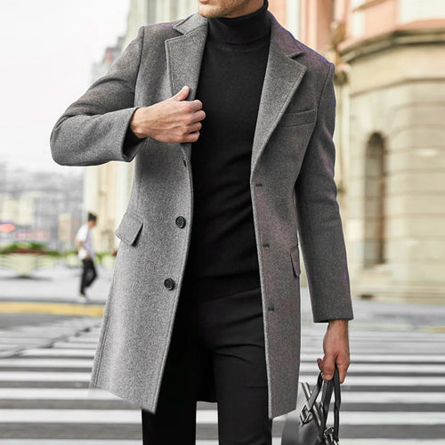 Man wearing grey men's tailored overcoat with notched lapel and button closure on city street