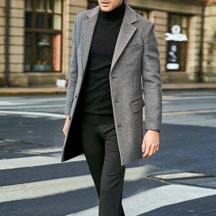 Rear view of men's tailored overcoat showing clean silhouette and shoulder construction