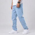 Men's wide leg jeans in light blue denim with relaxed straight fit worn with white trainers