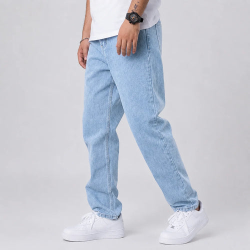 Men's wide leg jeans in light blue denim with relaxed straight fit worn with white trainers