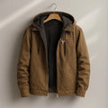 Men's hooded canvas jacket with sherpa lining in brown, featuring zip chest pocket and drawcord hood on hanger