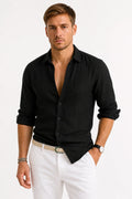 Men's linen shirt in black with classic collar and button-front closure, styled with white trousers