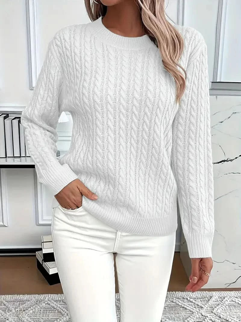 Close-up view of cable knit texture and ribbed crew neckline detail