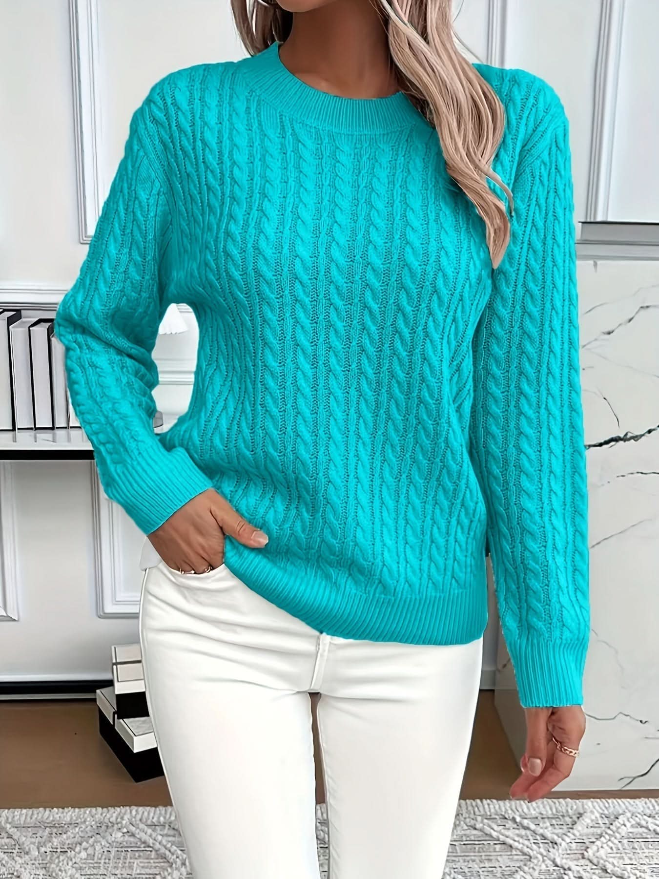 Three-quarter view showing crew neck and cable texture on white jumper