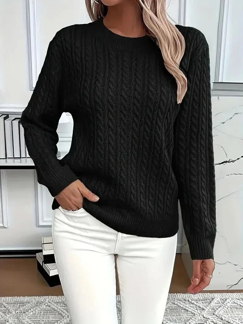 Flat lay of cable knit jumper displaying overall relaxed fit and ribbed trims