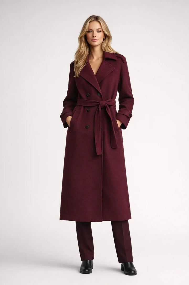 Women's long burgundy trench coat with double-breasted closure and tie belt, ankle-length silhouette with notched lapels