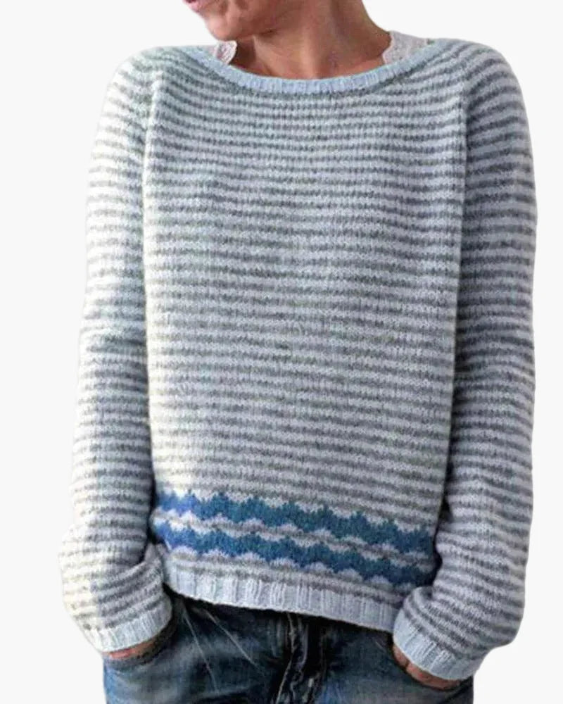Women's striped crew neck jumper with horizontal knit stripes and blue zigzag detail above the ribbed hem