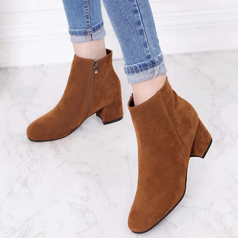Close-up of women's tan suede ankle boots showing square toe and block heel construction