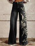 Women's high-waist wide-leg jeans in dark wash with floral embroidery detail running along the outer leg