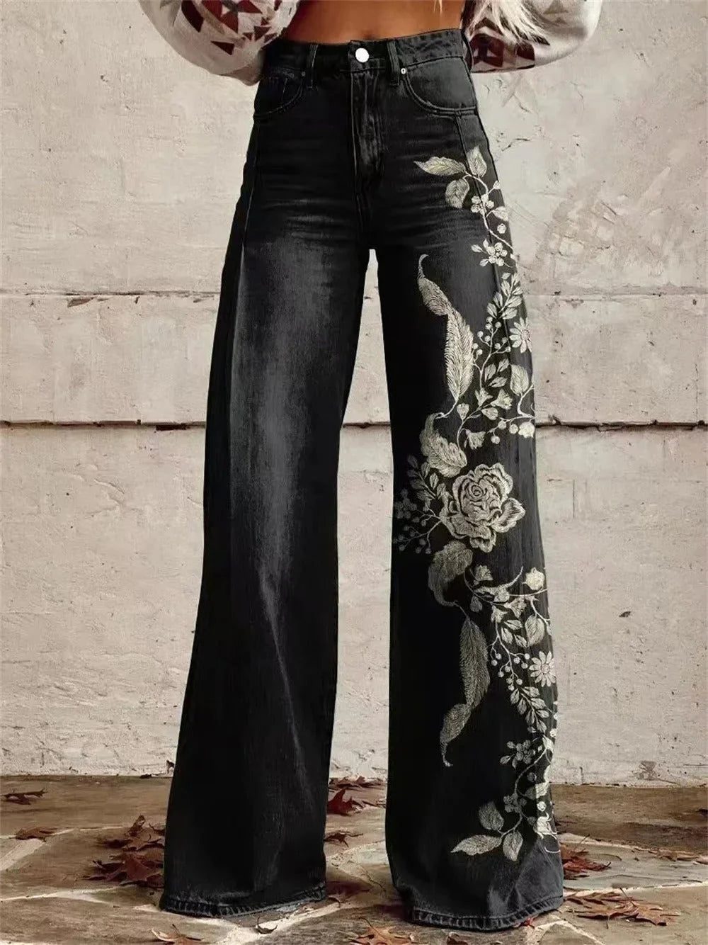 Women's high-waist wide-leg jeans in dark wash with floral embroidery detail running along the outer leg