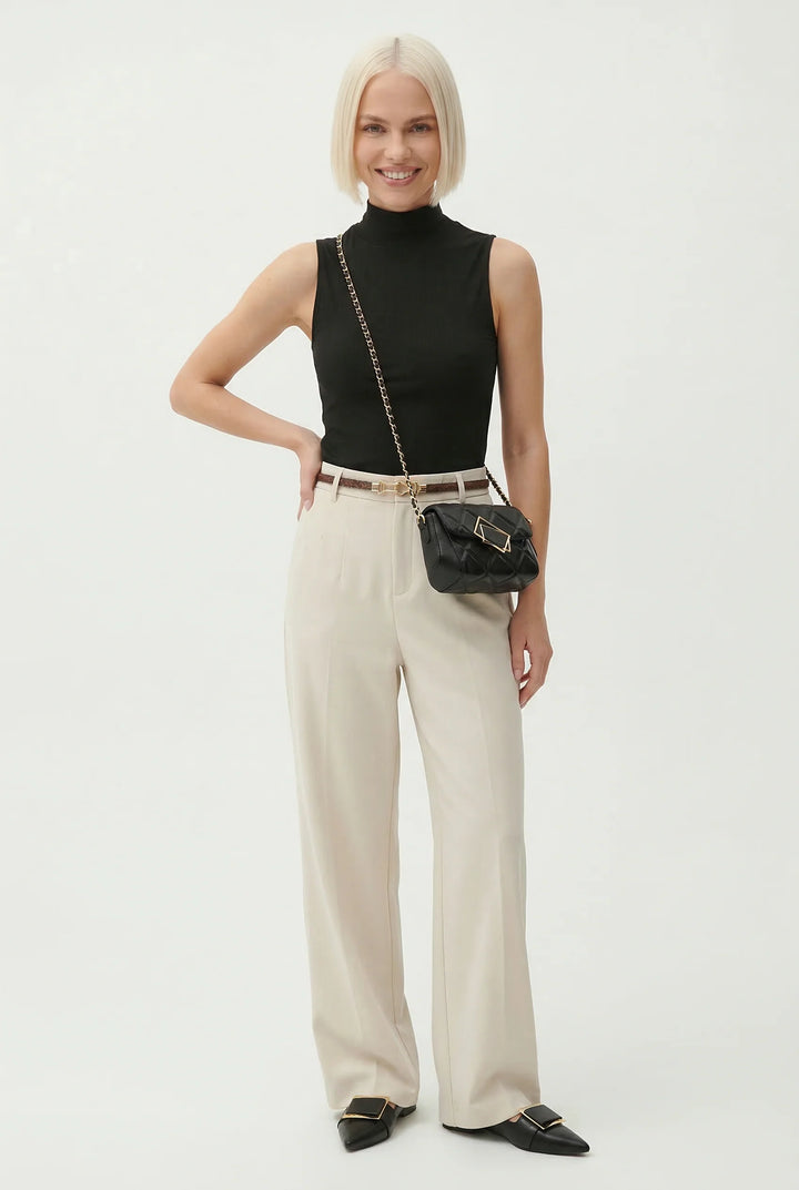 Beige wide leg wool trousers paired with black pointed flats for polished look