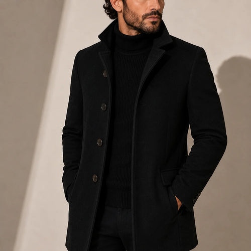 Men's tailored coat with stand collar and button-front closure in solid black worn over turtleneck