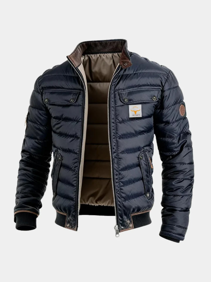 Men's quilted puffer jacket in navy with high collar and chest pockets on grey background