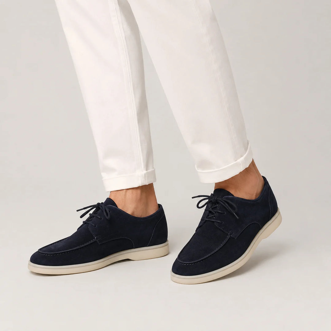Men's navy suede loafers with lace-up design styled with white trousers for smart casual wear