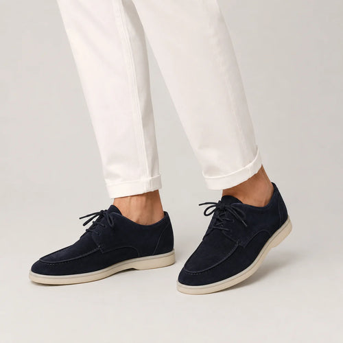 Men's navy suede loafers with lace-up design styled with white trousers for smart casual wear