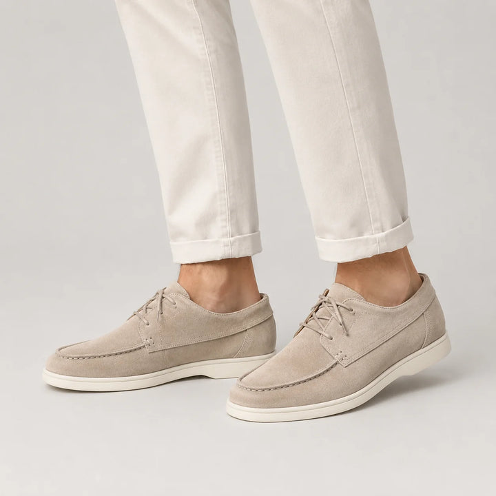 Close-up view of men's suede loafers showing lace-up closure and contrast stitching detail