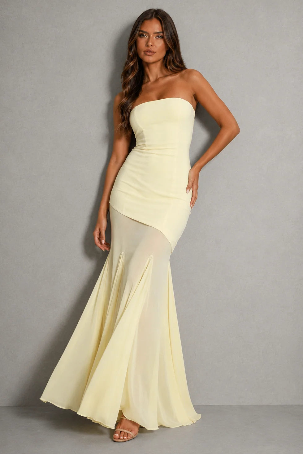 Strapless maxi dress with sheer overlay and asymmetric hem in pale lemon shade