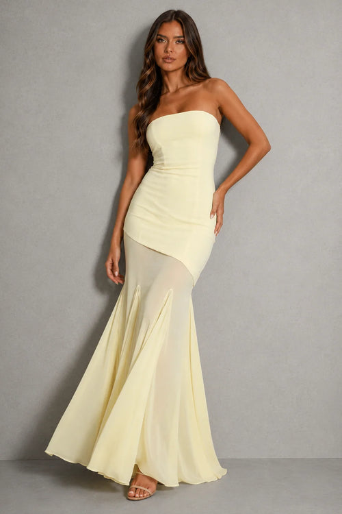 Strapless maxi dress with sheer overlay and asymmetric hem in pale lemon shade