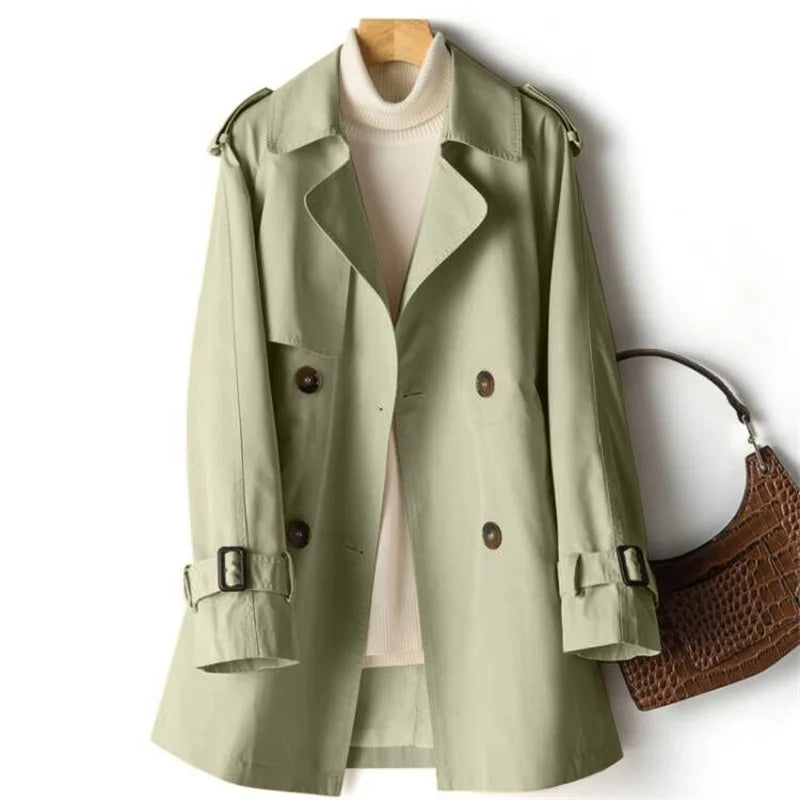 Women's sage green double-breasted trench coat with notched lapels and adjustable cuff straps on display