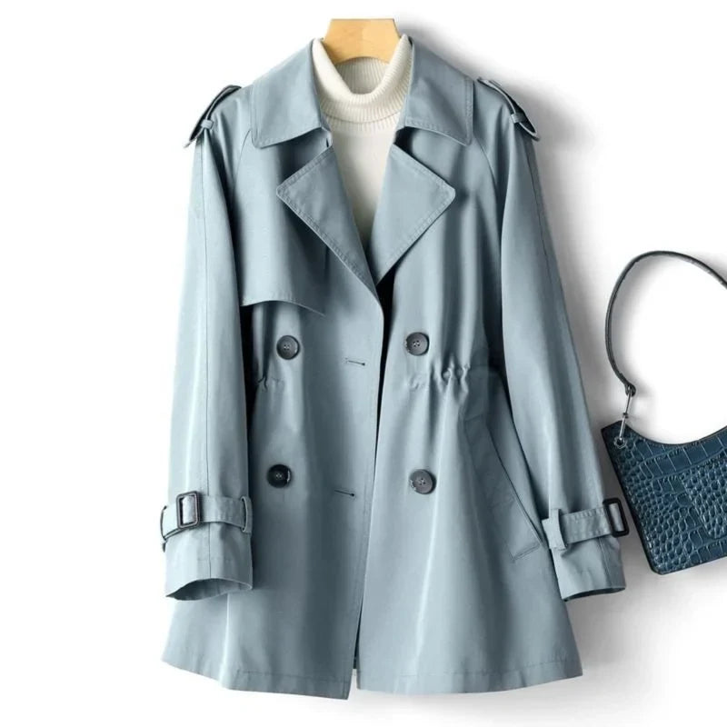 Close-up view of double-breasted button closure and wide notched lapels on sage trench coat