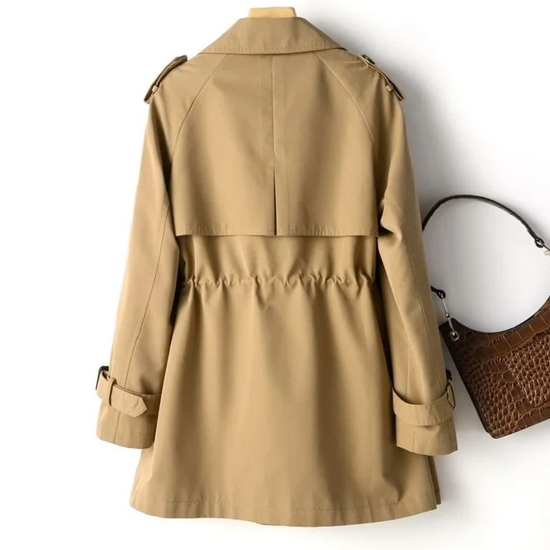 Women's trench coat styled over cream turtleneck jumper with relaxed fit through body