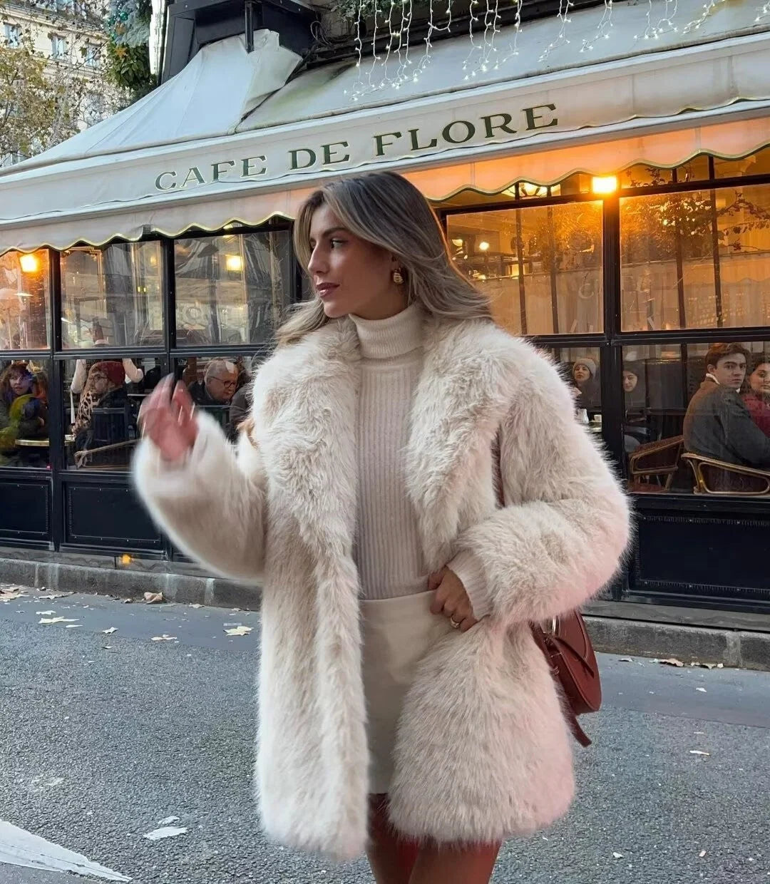 Mid-length faux fur coat with fluffy texture and relaxed fit worn with denim jeans