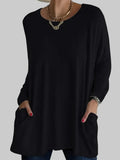 Women's oversized tunic top with front pockets in black, featuring round neck and long sleeves with relaxed fit