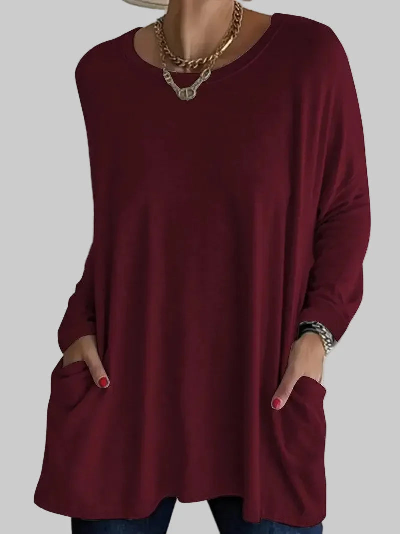 Side angle of women's black tunic top with oversized fit and long length falling below the hip