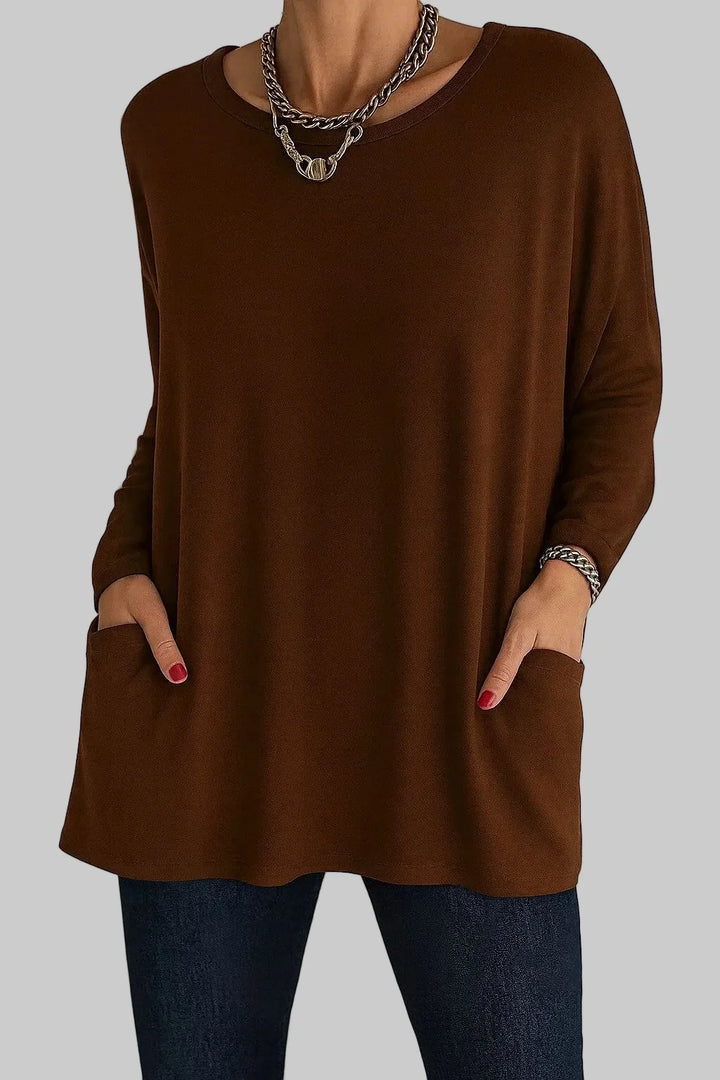 Women's oversized tunic top styled with slim jeans showing relaxed casual silhouette and long sleeves