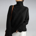Women's turtleneck jumper in black with relaxed fit and ribbed knit texture worn with white trousers