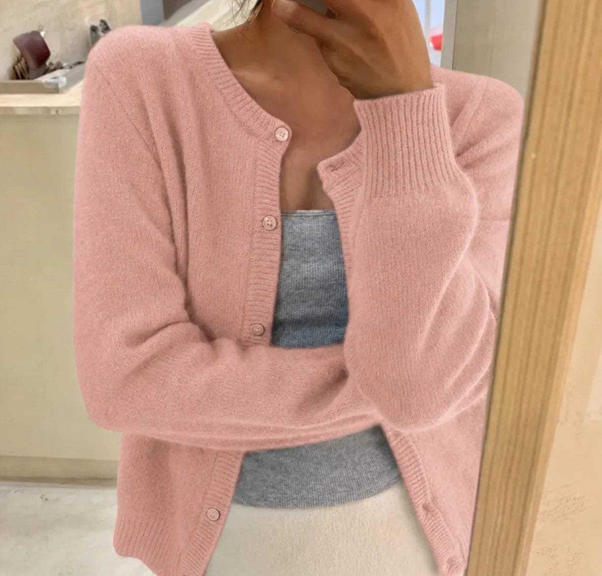Close-up of fine-gauge knit texture and button detail on women's cropped cardigan