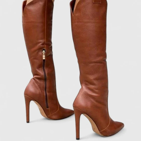 Close-up of pointed toe and stiletto heel on women's knee-high boots with smooth finish