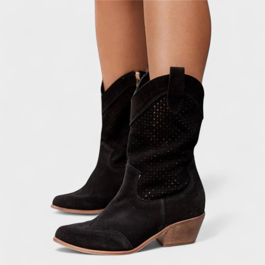 Women's beige cowboy boots paired with casual outfit, showcasing mid-calf height and pull-on design.