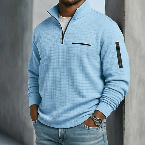 Close-up view of men's quilted sweatshirt showing half-zip collar and chest pocket detail