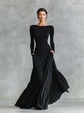 Model wearing black ruched maxi dress with boat neckline and long sleeves for formal occasions
