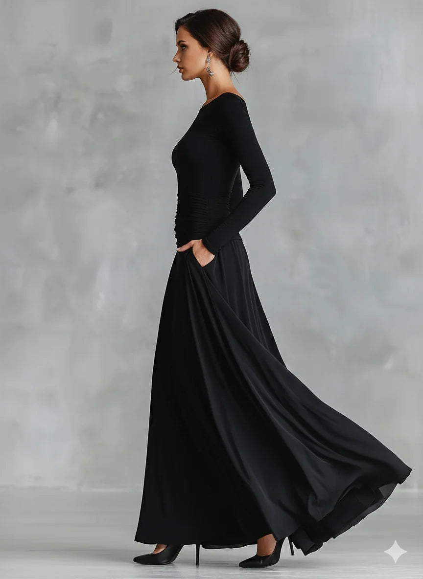 Close-up view of ruched waist detailing on black maxi dress with flowing skirt