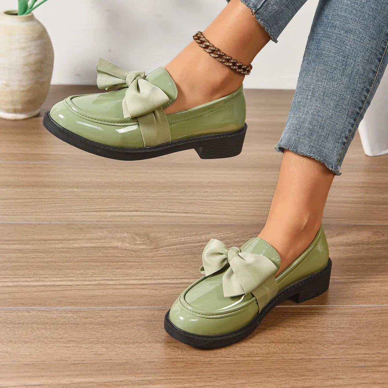 Side angle of patent loafers showing block heel and structured upper