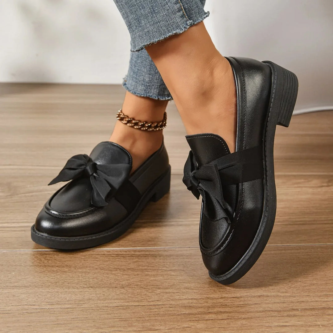 Side view of women's patent loafers with low block heel and slip-on design