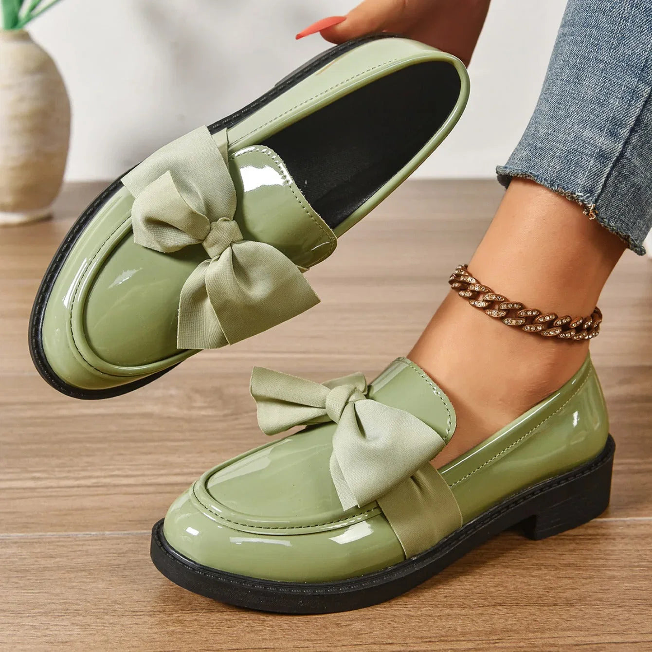 Bow detail loafers in glossy finish paired with cropped jeans on model