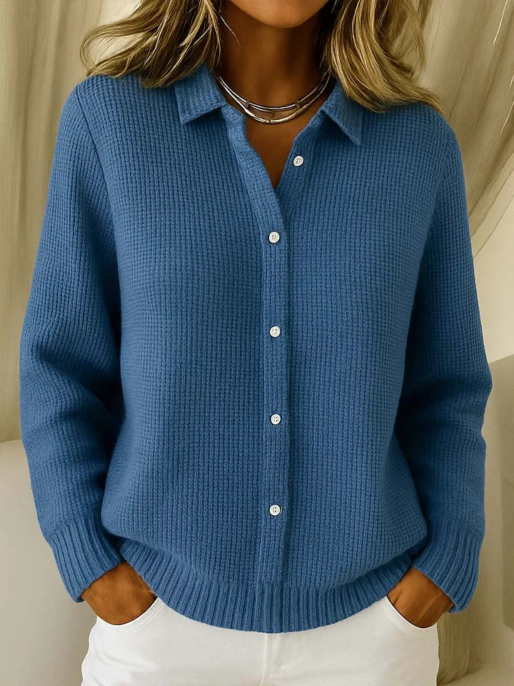 Detail of collared cardigan showing ribbed knit texture and button closure