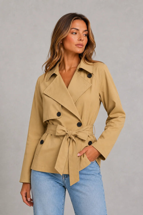 Close-up of cropped trench jacket showing wide lapel collar and button fastening detail on beige fabric