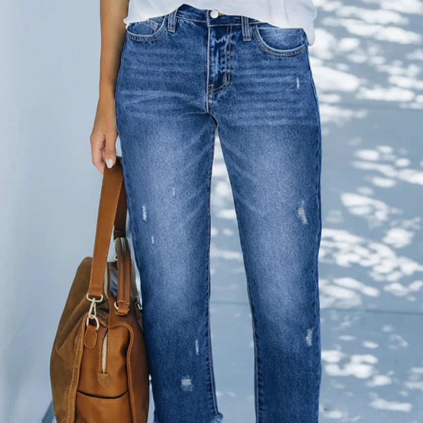 Close-up of distressed detail and faded wash on wide-leg jeans