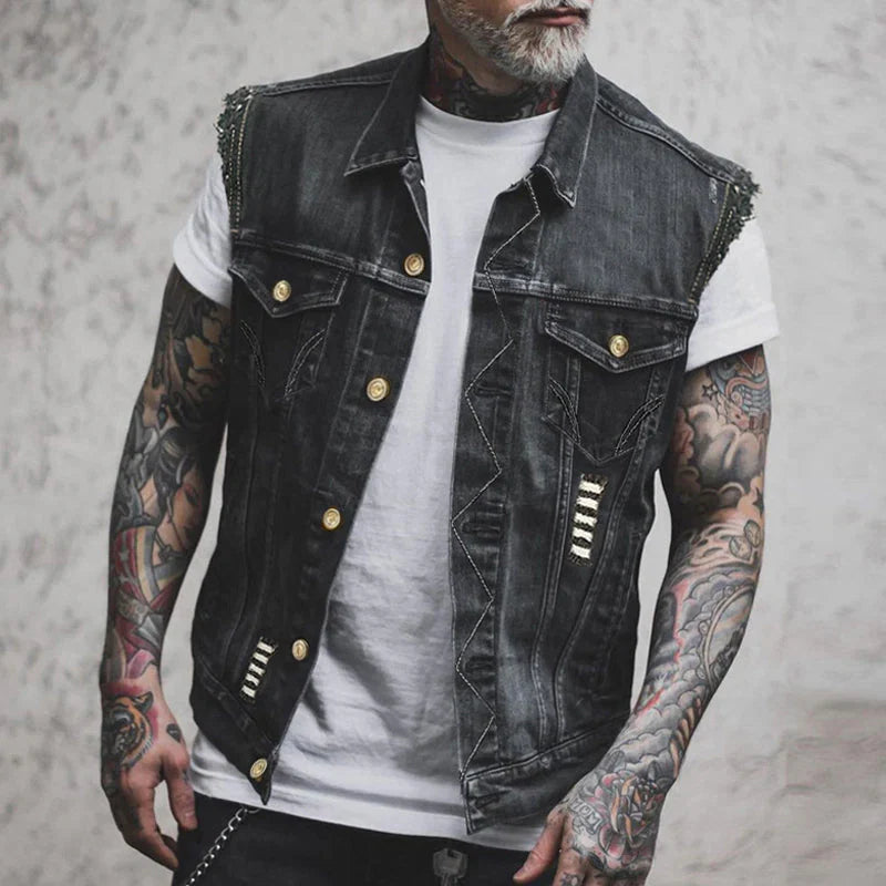 Men's distressed denim vest with button-up front and metallic stud detailing on shoulders