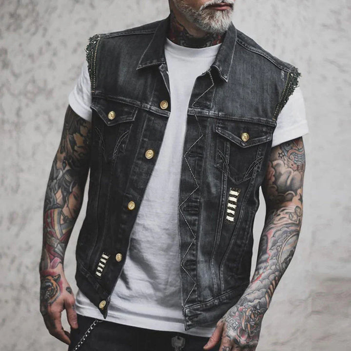 Men's distressed denim vest with button-up front and metallic stud detailing on shoulders
