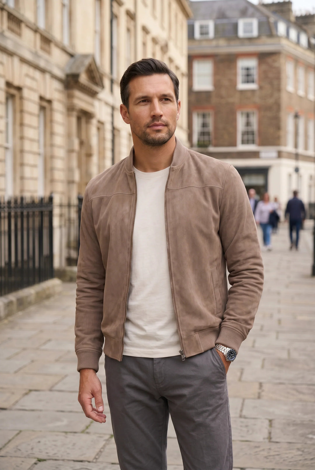 Men's beige bomber jacket styled with white tee and grey trousers for smart-casual look