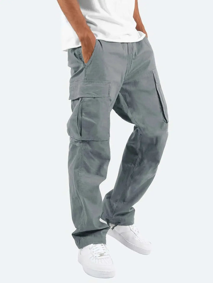 Men's cargo trousers paired with white trainers showing full-length relaxed fit and functional pocket placement
