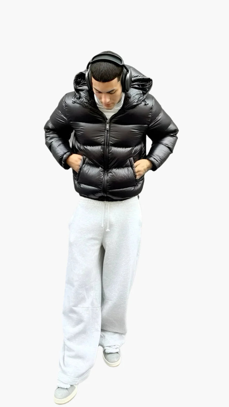 Men's puffer jacket in black with quilted panels, adjustable hood, and full-length zip closure for winter wear