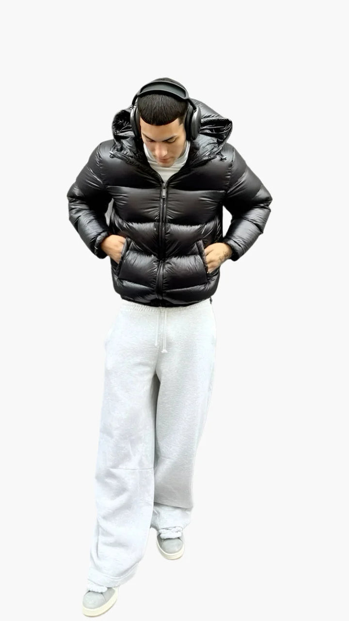 Men's puffer jacket in black with quilted panels, adjustable hood, and full-length zip closure for winter wear