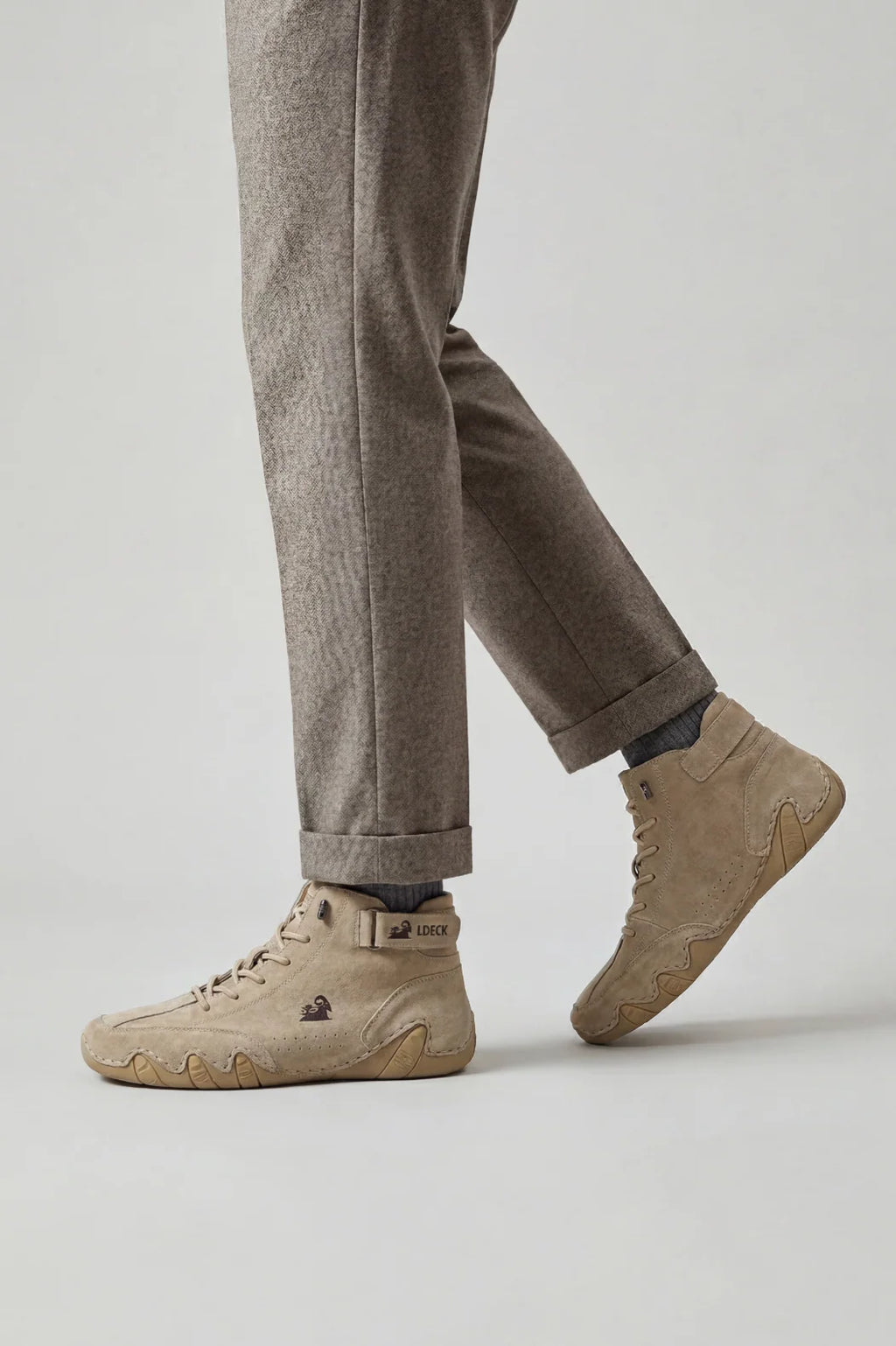 Side view of men's high-top trainers showing structured ankle strap and perforated detailing